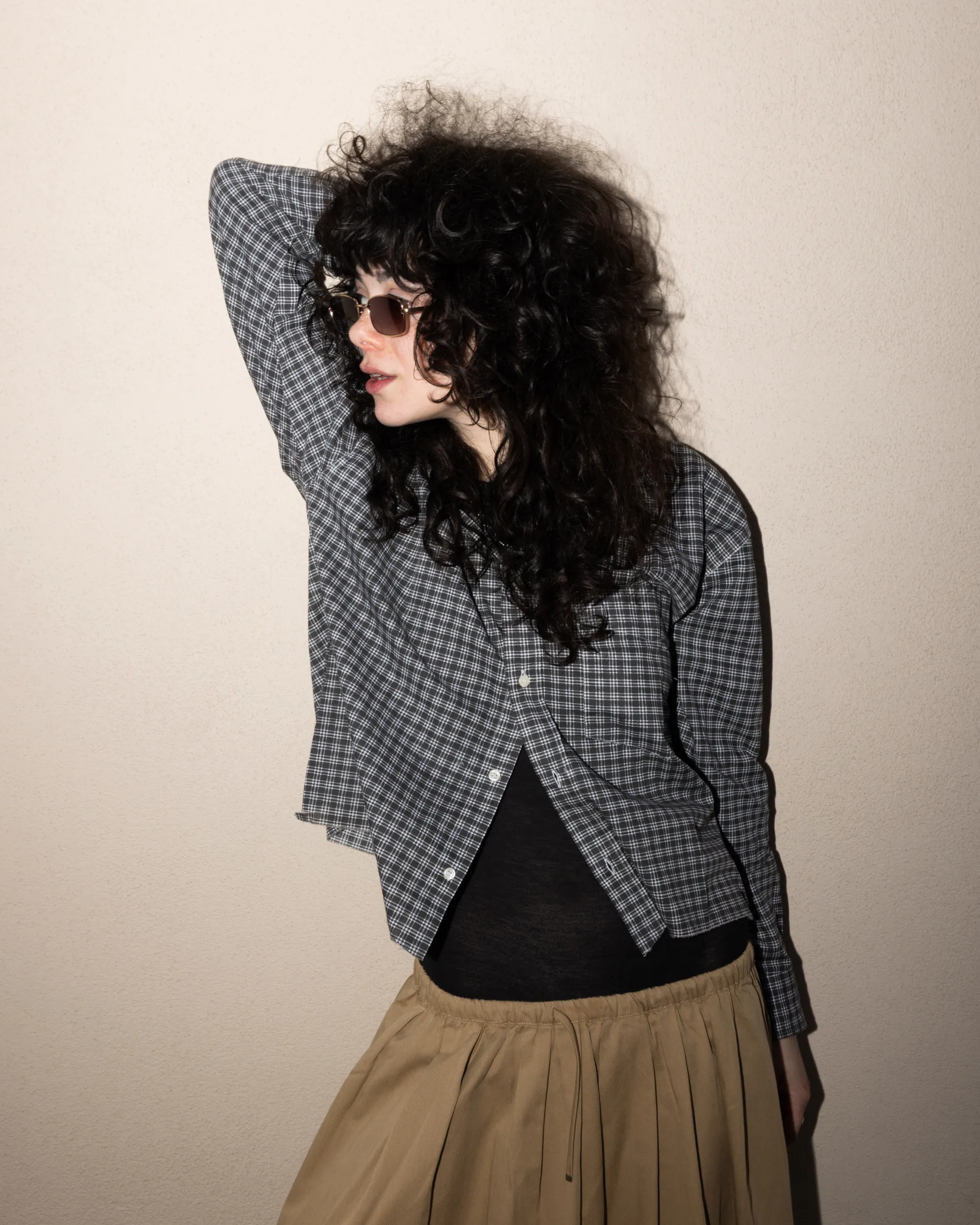 Model in a plaid shirt and sunglasses.
